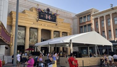 The covered queue is surrounded by barriers featuring