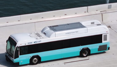 A bus riding by the water