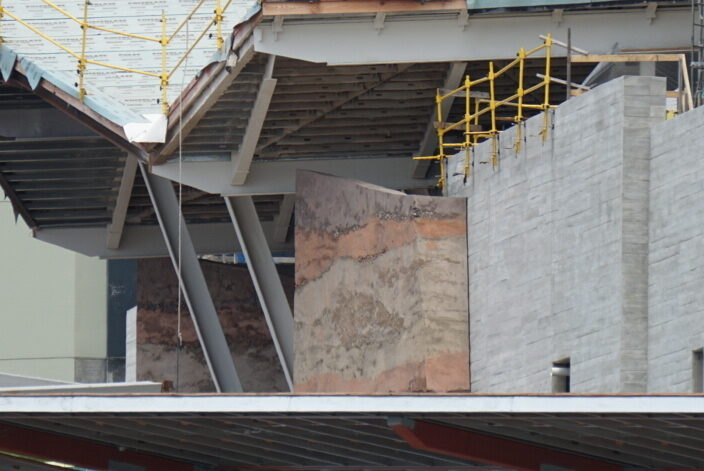 Rock texture is being added to the walls surrounding the porte-cochère. As you can see above, walls have gone up around some of the exterior frames of the building.