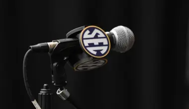 SEC Football Media Days podium stands in front of a large SEC-branded backdrop featuring a blue football helmet at the JW Marriott Tampa Water Street.