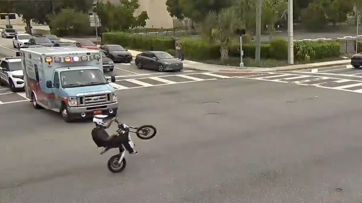 photo shows e-bike on back wheel in front of ambulance