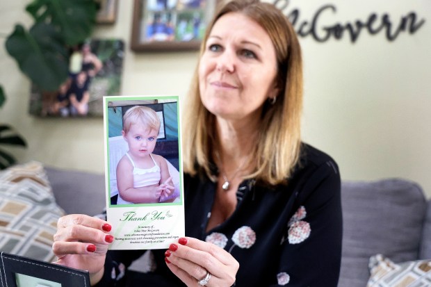 Casey McGovern holds a photo of her daughter, Edna Mae, in her home in Coral Springs on Tuesday, July 14, 2026. McGovern lost her daughter to drowning in 2009 and is now a water safety advocate. (Carline Jean/South Florida Sun Sentinel)