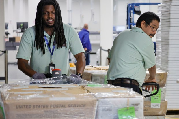 Christopher Foon steers around David Mortin as the two load some of the 105,000 vote-by-mail ballots to be mailed out for the 2026 Primary Election at the Main Elections Office in West Palm Beach on Friday, July 10, 2026. (Amy Beth Bennett / South Florida Sun Sentinel)