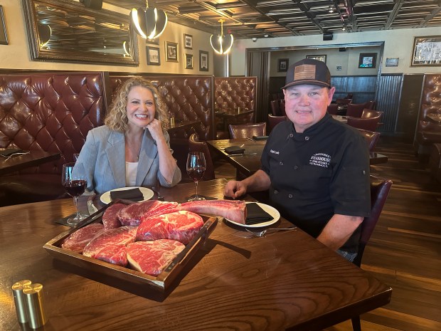 Chef-host Michelle Bernstein, left, and Okeechobee Steakhouse owner Ralph Lewis, right, in a scene from the new PBS documentary "Legacy on a Plate: The Restaurants That Built South Florida" which features the West Palm Beach restaurant. (PBS / Courtesy)