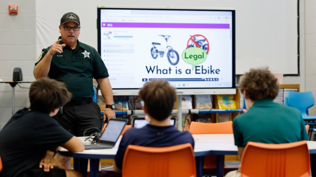 Osceola County deputy Ron Cole teaches an e-bike safety class at the Celebration K-8, on Wednesday, April 8, 2026. On Tuesday, neighboring Orange County School Board will vote on a district-wide e-bike ban for students without a driver's license. (Ricardo Ramirez Buxeda/ Orlando Sentinel)
