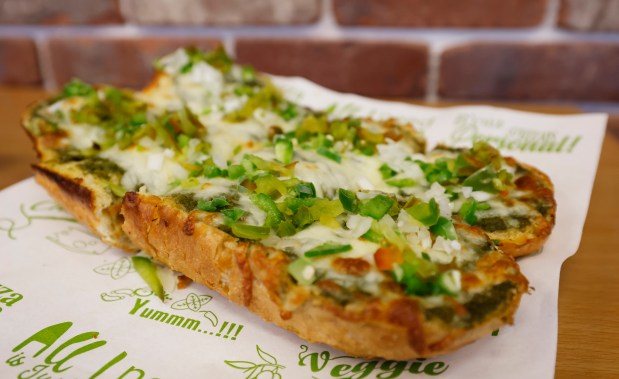 Signature Desi Garlic Bread ("Our classic garlic bread, with a fresh savory cilantro mint chutney, topped with cheese and diced onion and peppers.") from Singas Famous Pizza on 1790 West Sand Lake Road in Orlando, on Wednesday, July 22, 2026. (Ricardo Ramirez Buxeda/ Orlando Sentinel)