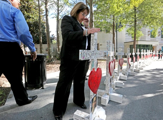 After placing the the 49th white "Pulse Tribute" cross at the Orlando Regional History Center Orange County Mayor Teresa Jacobs, right, becomes emotional placing her hand on the cross. Forty-nine crosses were moved from the Orlando Health campus to Orange County Regional History Center in 2016. (Orlando Sentinel file)