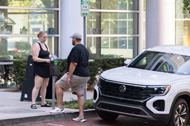 Downtown visitor pays with coins using parking meter in downtown Orlando, FL, Thursday, July 16, 2026. (Barrett Walsh/Orlando Sentinel)