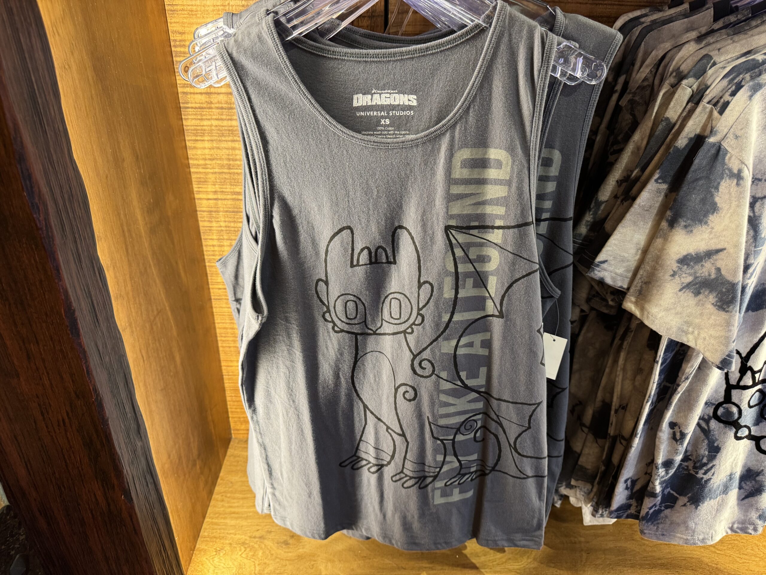 The gray tank top has a lineart image of Toothless and