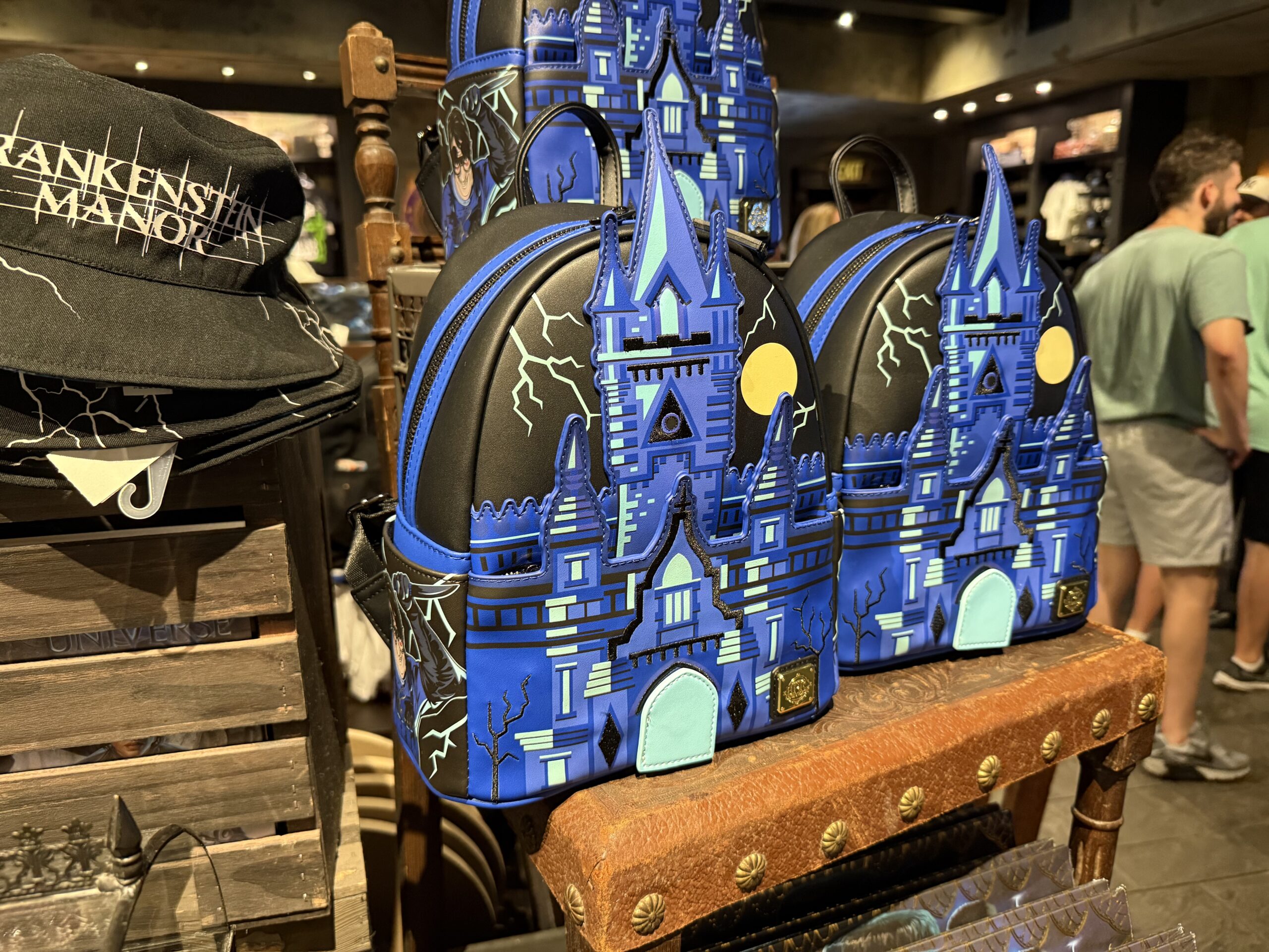 This faux leather bag features a bright blue depiction of Frankenstein Manor on the front. It's set against a black sky with lightning and a full moon.