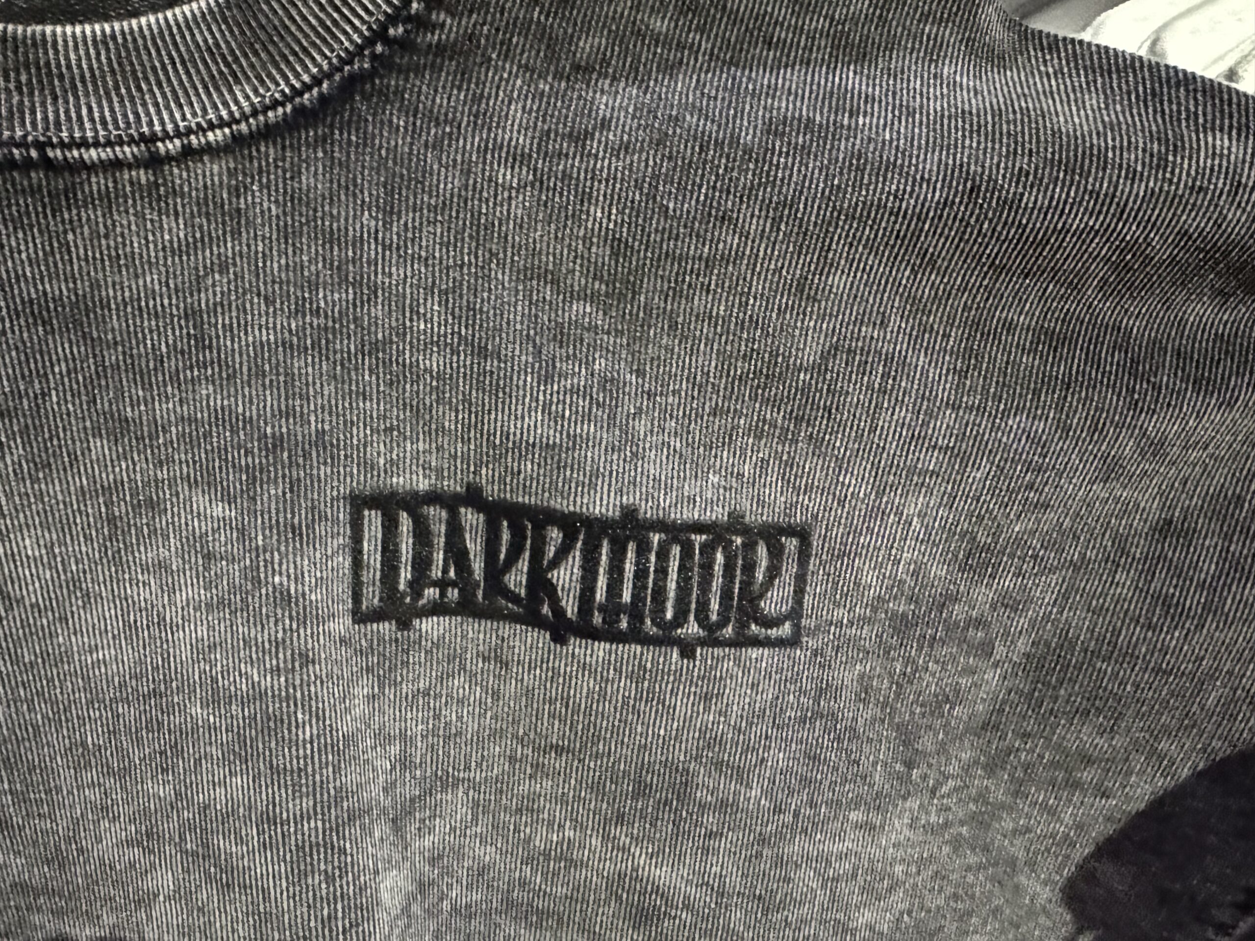The Spirit Jersey is a heavy material and feels like corduroy. It's a weathered black with "Darkmoor" in puffy ink on the left chest.