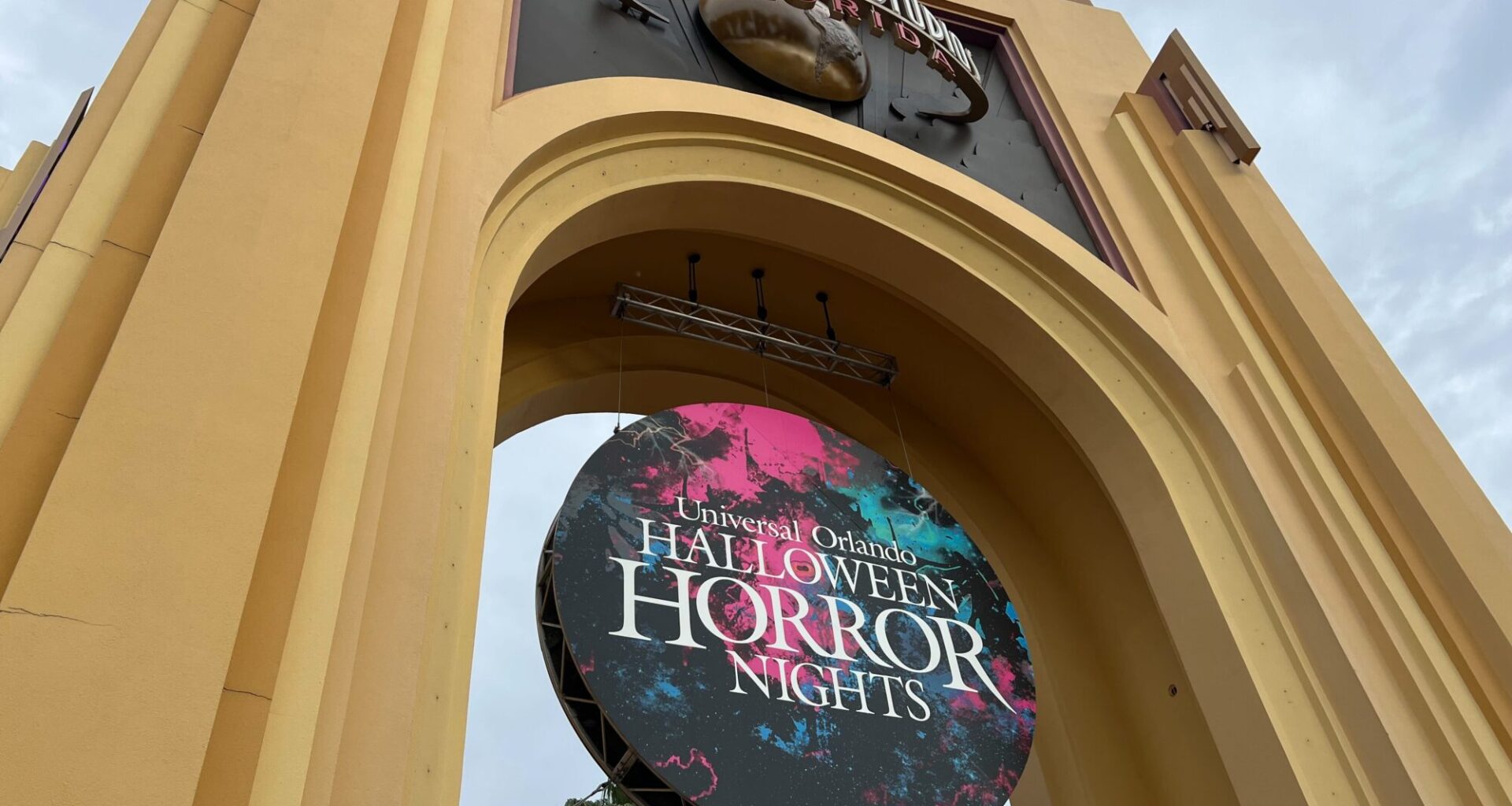 Entrance archway at Universal Studios Florida with a large circular sign advertising