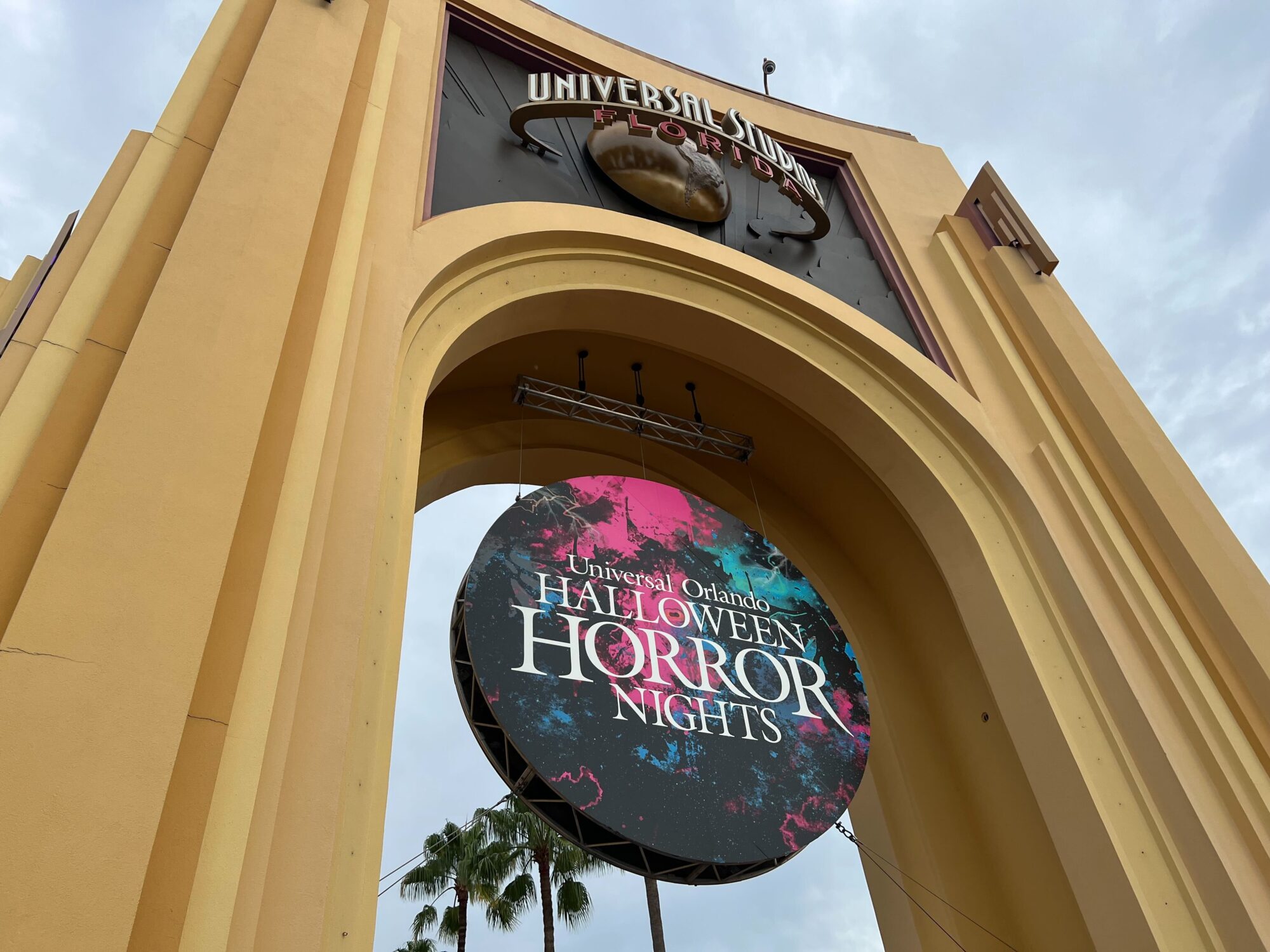 Entrance archway at Universal Studios Florida with a large circular sign advertising