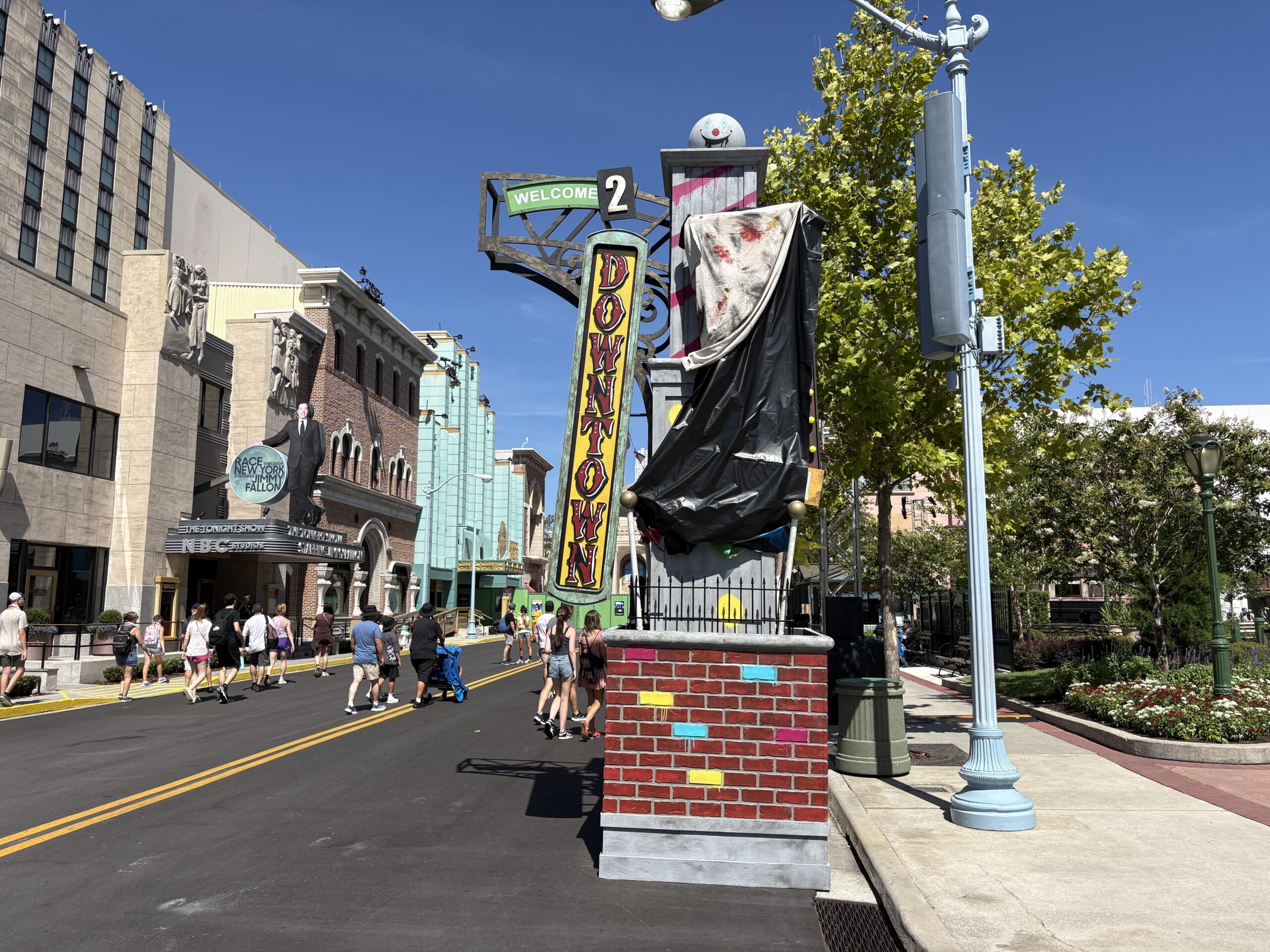 The balls on top have been painted with clown faces. Each column also has some kind of tarp-wrapped prop attached. These kinds of hidden props are usually either spoilers for yet-to-be announced offerings or too gruesome to be exposed to day guests.