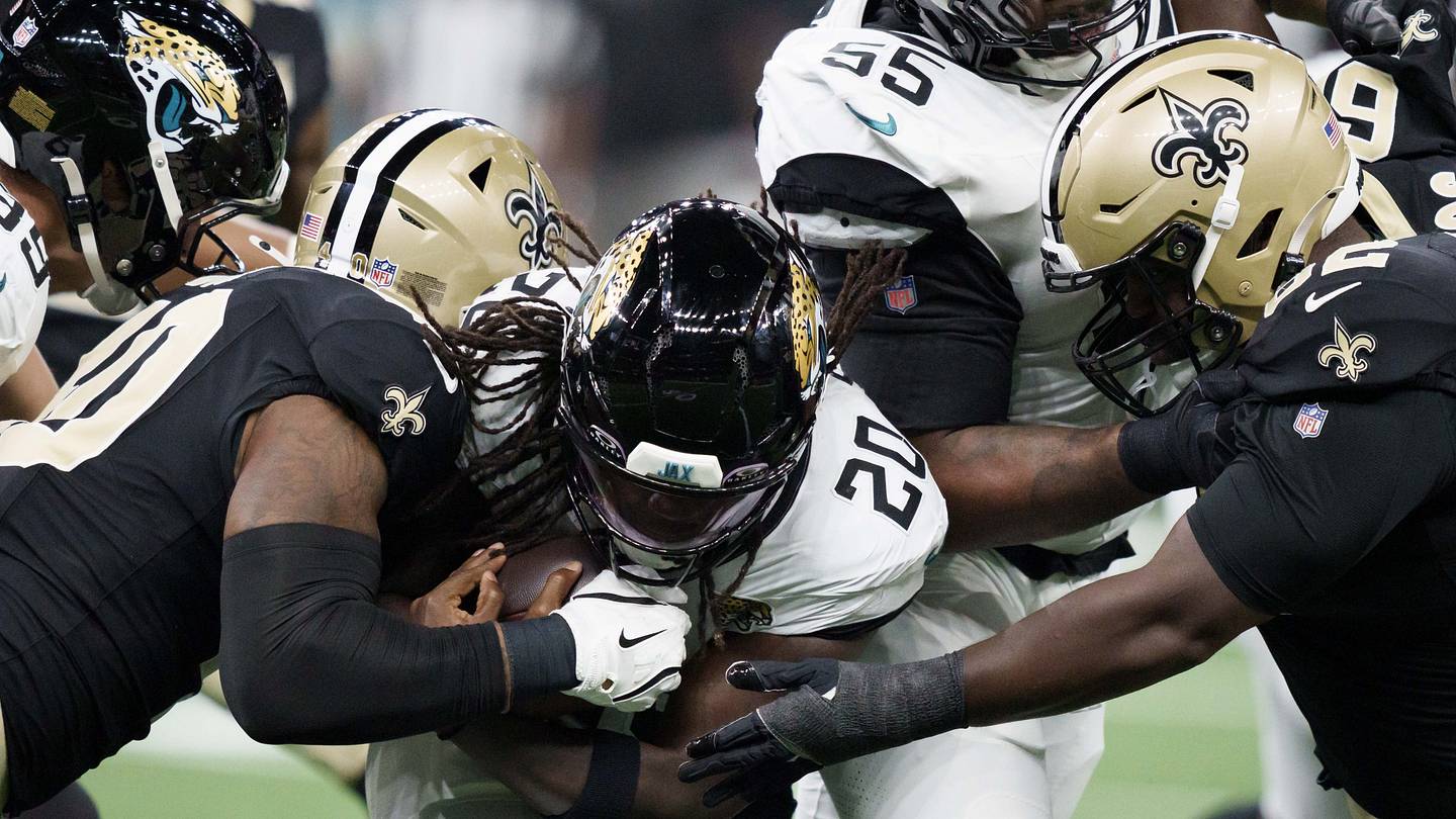 Aug 15, 2026; New Orleans, Louisiana, USA; New Orleans Saints linebacker Kaden Elliss (55) and defensive lineman Jay'viar Suggs (62) tackle Jacksonville Jaguars running back Deejay Dallas (20) during the first quarter at Caesars Superdome.