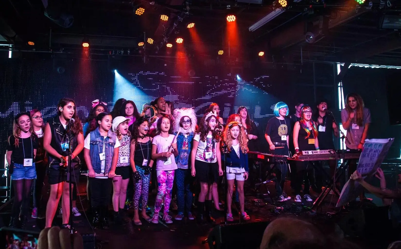 Photo of a group of young girls posing by a stage in Miami.