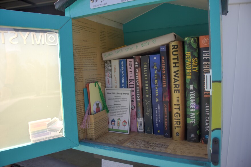 A case full of books and bookmarks. The inside of the case has pages of books glued to the surface.