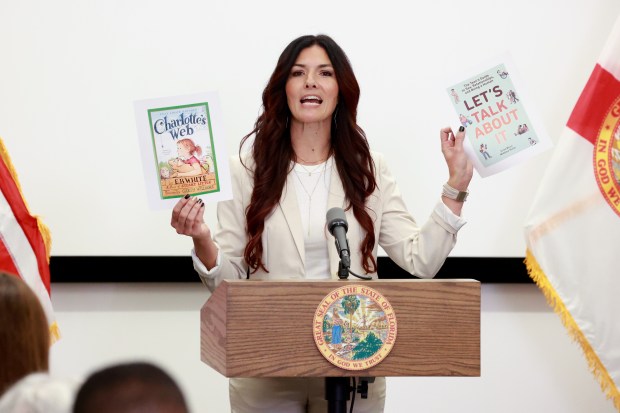 Orange County School Board Member Alicia Farrant holds up the cover of a book 'Charlotte's Web' and the book 'Let's Talk About It' during a news conference held by Florida Gov. Ron DeSantis at UCF Lake Nona Cancer Center in Orlando on Thursday, Feb. 15, 2024. Farrant, who was a member of the conservative Moms for Liberty group, lost her election for the countywide school board chair last week to Angie Gallo. (Rich Pope, Orlando Sentinel)