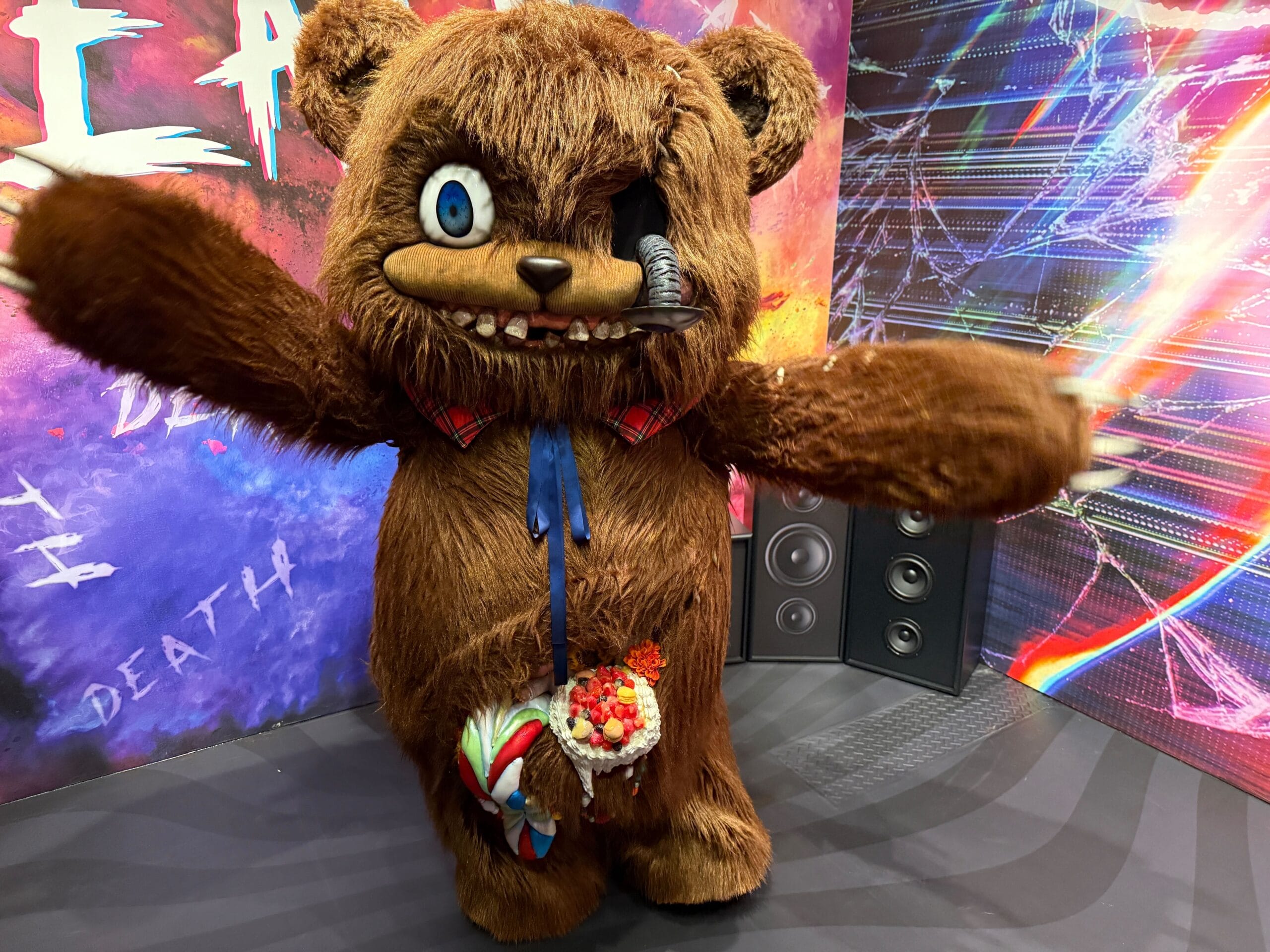 Person in a scary, damaged HamiKuma teddy bear costume stands with arms outstretched at Universal Studios Japan.