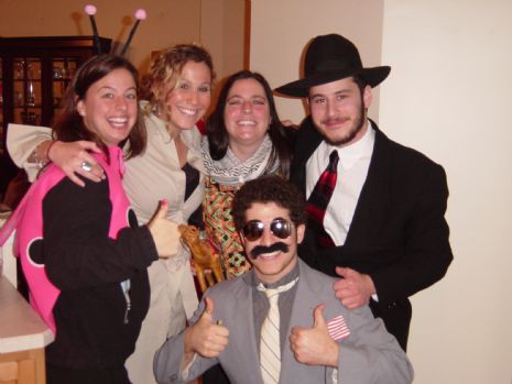 College students in various costumes pose for a photo, all smiling