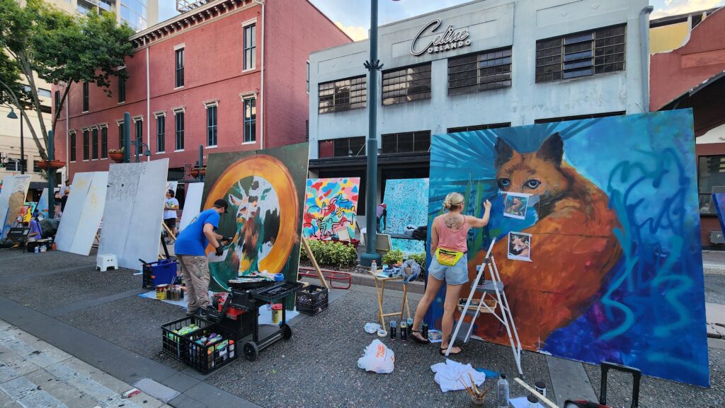 Artists create colorful murals in Downtown Orlando for the Orlando Mural Festival 2024.