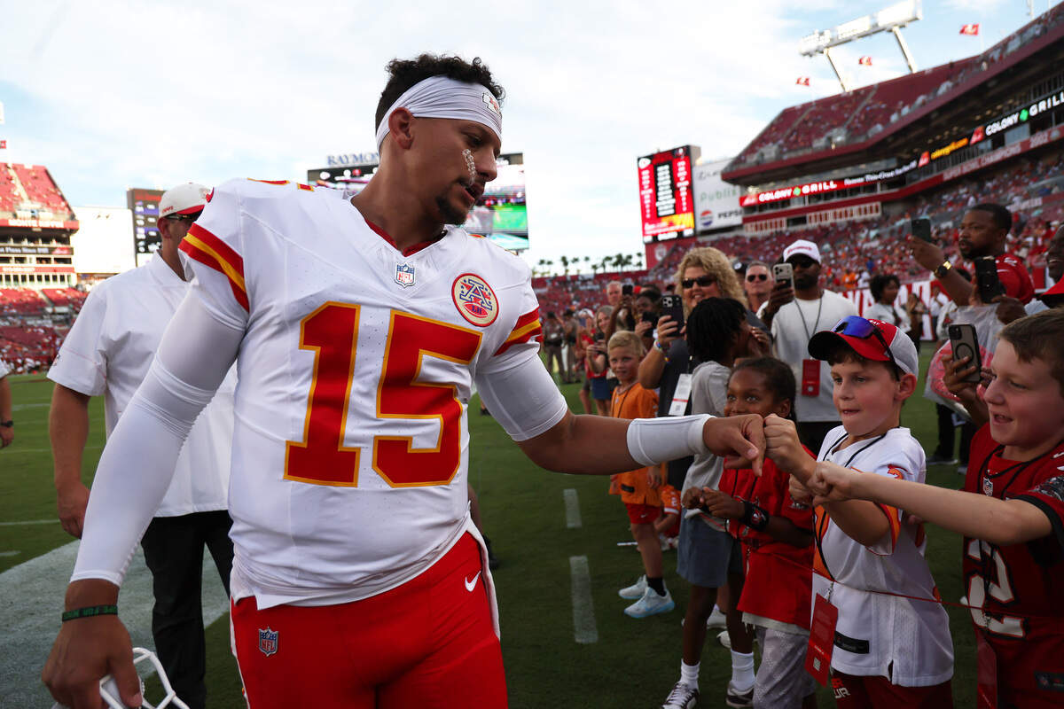 Kansas City Chiefs quarterback Patrick Mahomes high-fives young fans before a preseason NFL game against the Buccaneers at Raymond James Stadium in Tampa.