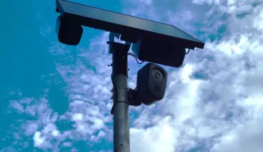 A Flock camera with a solar panel on top.