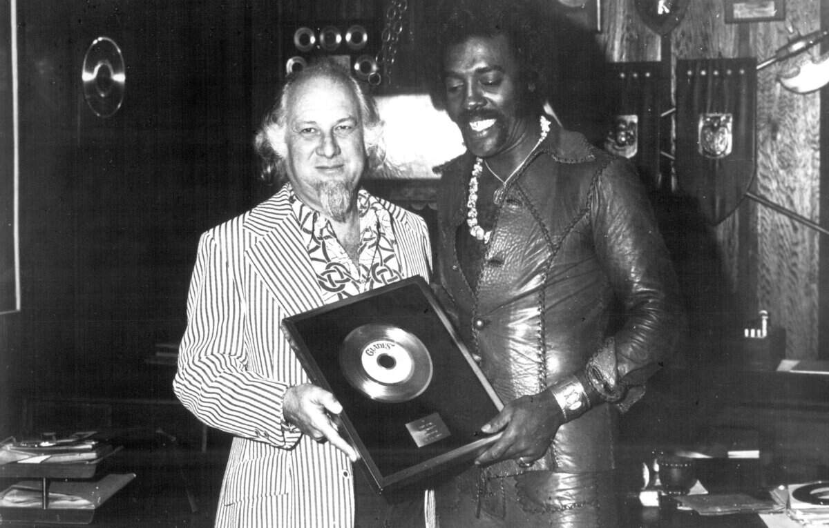 Henry Stone, left, founder and president of Miami’s T.K. Productions, presents singer Latimore, right, with a gold record for his 1974 No. 1 R&B single and Top 40 crossover pop hit, "Let's Straighten it Out," in this file photo from 1974.