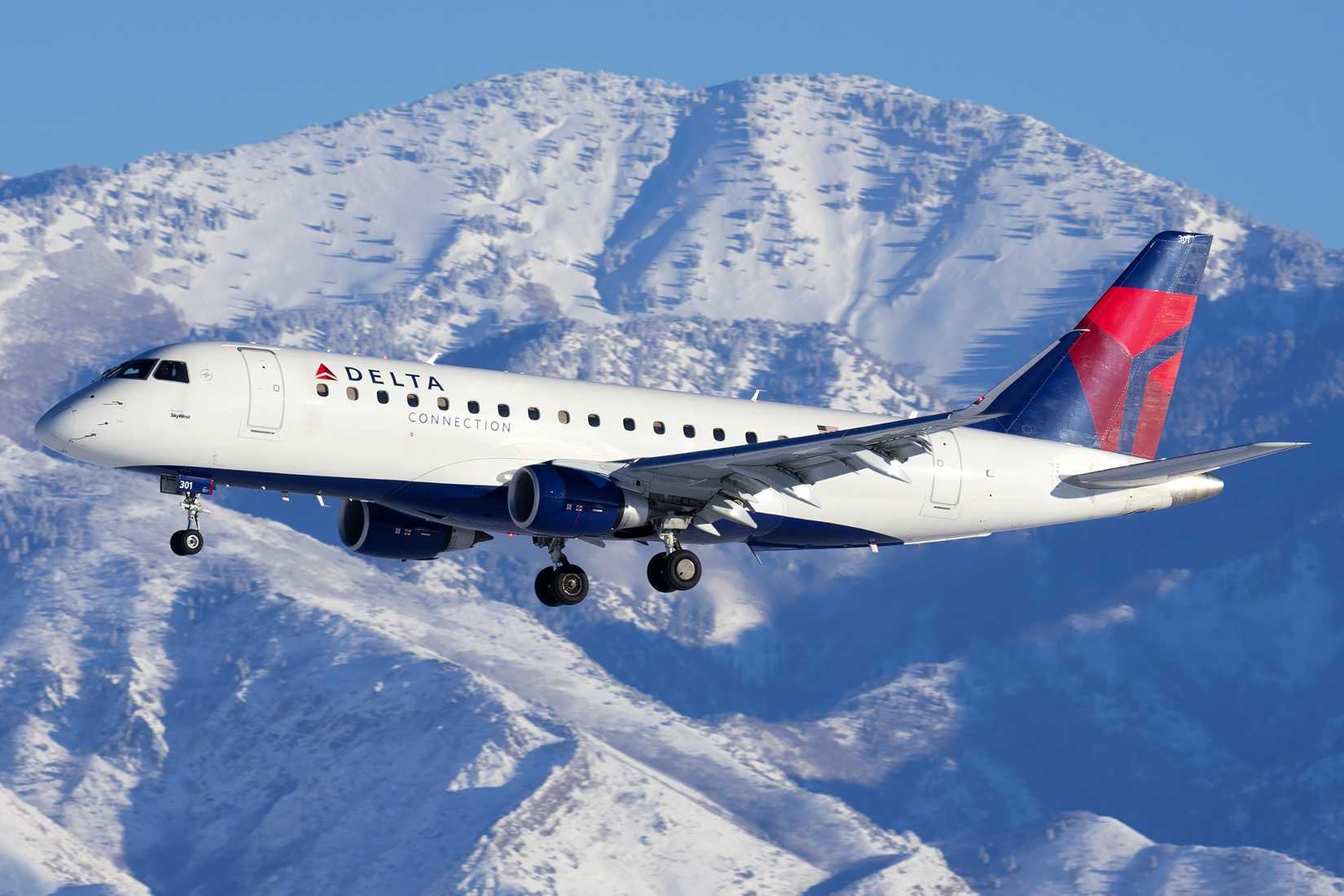 Delta Air Lines Embraer E175 with snowy mountains