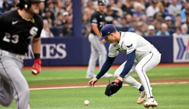 Chicago White Sox's Andrew Benintendi, left, runs to first base on a fielding error by Tampa Bay Rays pitcher Griffin Jax, right, during the first inning of a baseball game Sunday, Aug. 2, 2026, in St. Petersburg, Fla. (AP Photo/Jason Behnken)