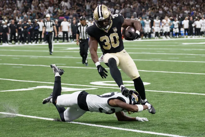 Aug 15, 2026; New Orleans, Louisiana, USA; New Orleans Saints running back Audric Estime (30) leaps over Jacksonville Jaguars defensive back Jabbar Muhammad (37) for a touchdown run during the first quarter at Caesars Superdome. Mandatory Credit: Matthew Hinton-Imagn Images