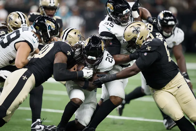 Aug 15, 2026; New Orleans, Louisiana, USA; New Orleans Saints linebacker Kaden Elliss (55) and defensive lineman Jay'viar Suggs (62) tackle Jacksonville Jaguars running back Deejay Dallas (20) during the first quarter at Caesars Superdome. Mandatory Credit: Matthew Hinton-Imagn Images