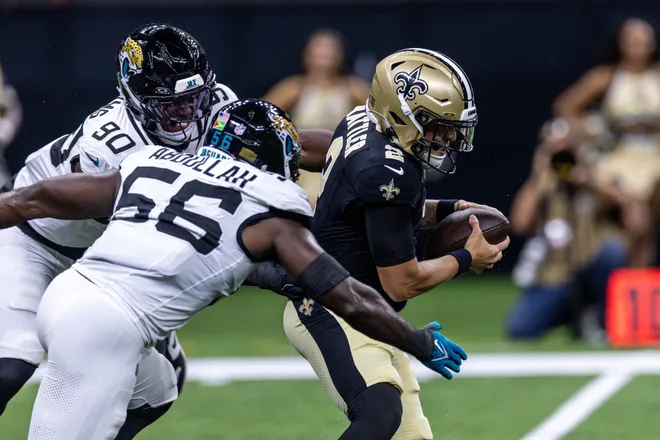 Aug 15, 2026; New Orleans, Louisiana, USA; New Orleans Saints quarterback Spencer Rattler (2) scrambles from the pocket and fumbles the ball against Jacksonville Jaguars linebacker Yasir Abdullah (56) during the first half at Caesars Superdome. Mandatory Credit: Stephen Lew-Imagn Images