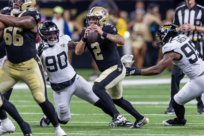 Aug 15, 2026; New Orleans, Louisiana, USA; New Orleans Saints quarterback Spencer Rattler (2) scrambles out the pocket against Jacksonville Jaguars defensive end Wesley Williams (90) during the first half at Caesars Superdome. Mandatory Credit: Stephen Lew-Imagn Images