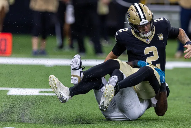 Aug 15, 2026; New Orleans, Louisiana, USA; New Orleans Saints quarterback Spencer Rattler (2) scrambles from the pocket and fumbles the ball against Jacksonville Jaguars linebacker Yasir Abdullah (56) during the first half at Caesars Superdome. Mandatory Credit: Stephen Lew-Imagn Images