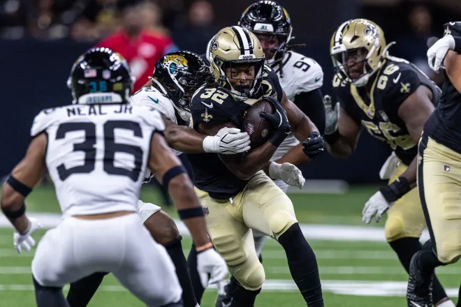 Aug 15, 2026; New Orleans, Louisiana, USA; New Orleans Saints running back Ty Chandler (32) runs against Jacksonville Jaguars safety Devin Neal (36) during the second half at Caesars Superdome. Mandatory Credit: Stephen Lew-Imagn Images