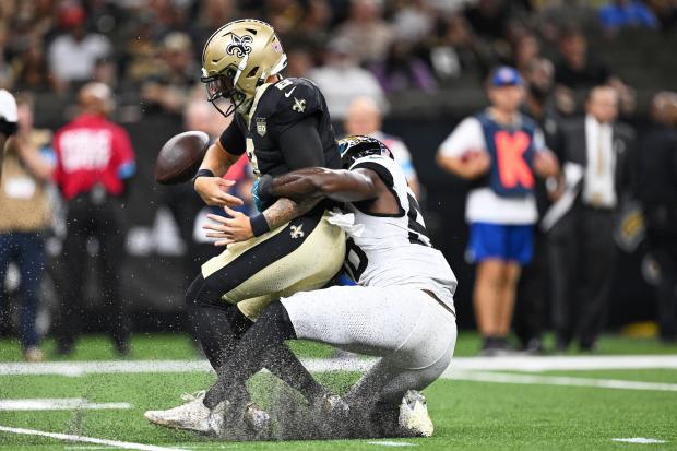 New Orleans Saints quarterback Spencer Rattler fumbles as he is sacked by Jacksonville Jaguars linebacker Yasir Abdullah, right, during the first half of an NFL preseason football game Saturday, Aug. 15, 2026, in New Orleans. (AP Photo/Ella Hall)