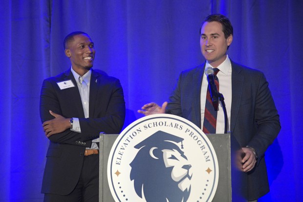 Past scholarship recipient Revel Lubin, left, listens as Elevation Foundation founder Chris King introduces him during the Elevation Scholars Awards Celebration Tuesday, May 14, 2019, in Orlando, Fla. (Phelan M. Ebenhack for the Orlando Sentinel)