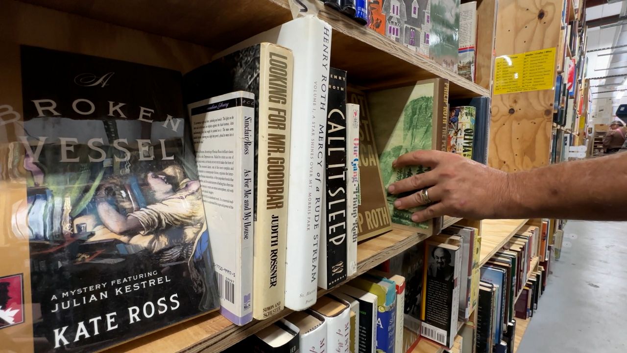 George Brooks shelves books at The Book Rescuers. (Spectrum News)
