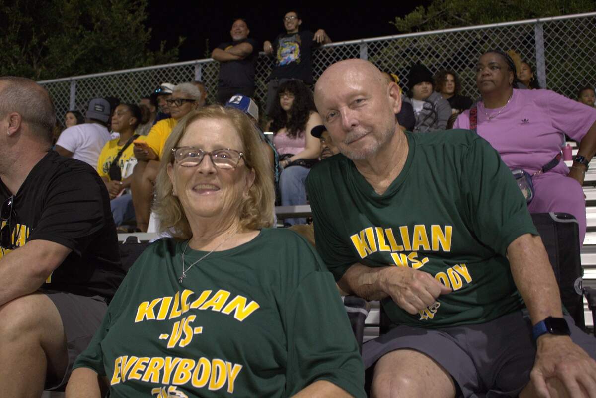 Miami Killian Senior High football fans Ann Tait and Chuck Tait watch their grandson’s first football game of the season on Aug. 14.