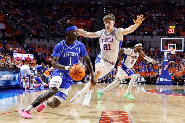 While playing for Kentucky guard Denzel Aberdeen (1) drives past Florida forward Alex Condon (21) during the team's meeting Feb. 14, 2026, in Gainesville. (AP Photo/Chris Watkins)