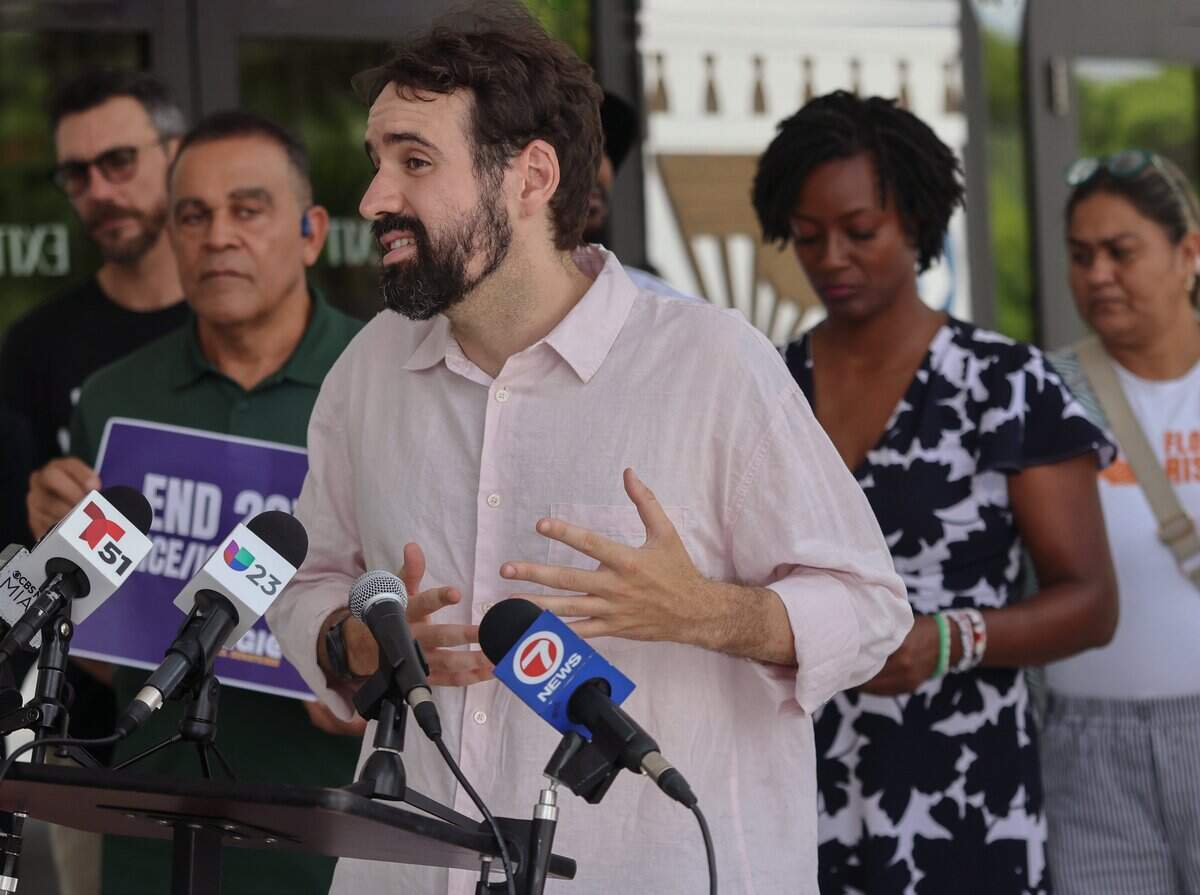 Activist Thomas Kennedy speaks outside Miami City Hall to call on city officials to end Miami's 287(g) agreement with ICE, especially now that Haitians have lost TPS, on Monday, Aug. 3, 2026.