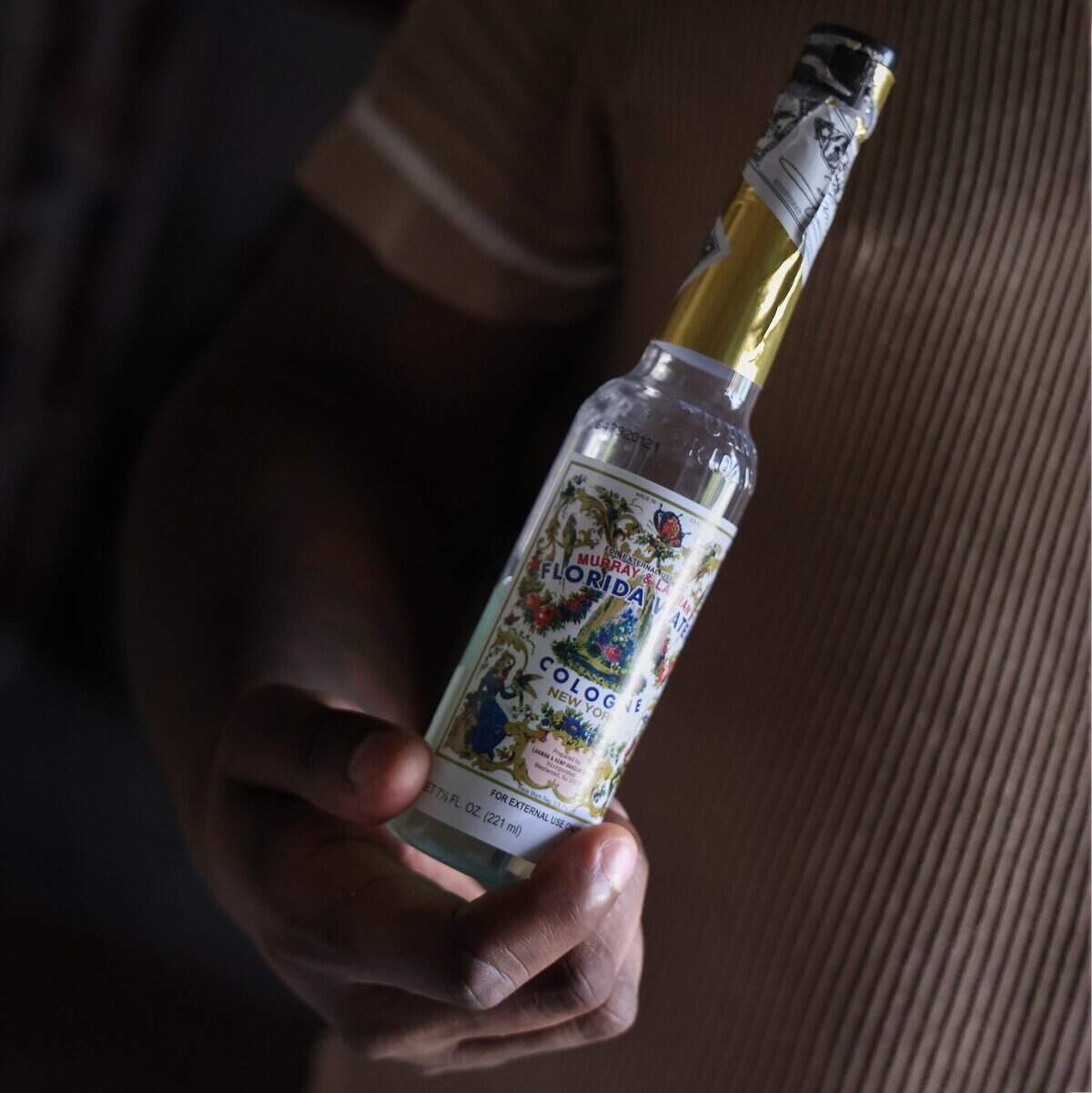 Universal Santeria priest Hector Giovanni Pizarro, known as “Oba Ti Lemi” to practitioners, holds a bottle of Florida Water Cologne prior to blessing the entrance of his botanica as he faces rising rent and the aftermath of a water-damaged storefront in Fort Lauderdale, Monday, July 20, 2026.