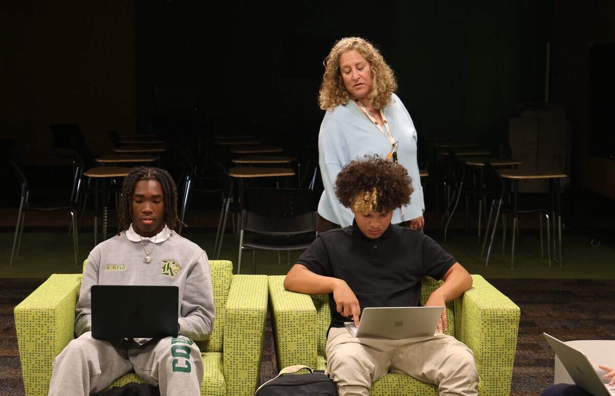 Miami Killian Senior High School teacher Lisa Oberlander, looks over the shoulders of Jamarquis Reid, 15, left, and Jayden Ramirez, 16, right, during the Digital Design art class on Monday, Aug. 24, 2026, in Miami. Killian has experienced the fastest-declining enrollment of any public school in Miami-Dade County, losing more than 80% of its students over the past 20 years.