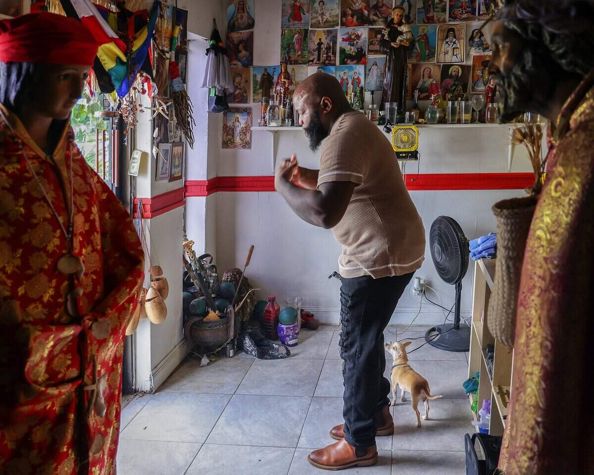 Universal Santeria priest Hector Giovanni Pizarro, known as “Oba Ti Lemi” to practitioners, performs a blessing with Florida Water at the entrance of Botanica Santo Tomas as he faces rising rent and the aftermath of a water-damaged storefront in Fort Lauderdale, Monday, July 20, 2026.