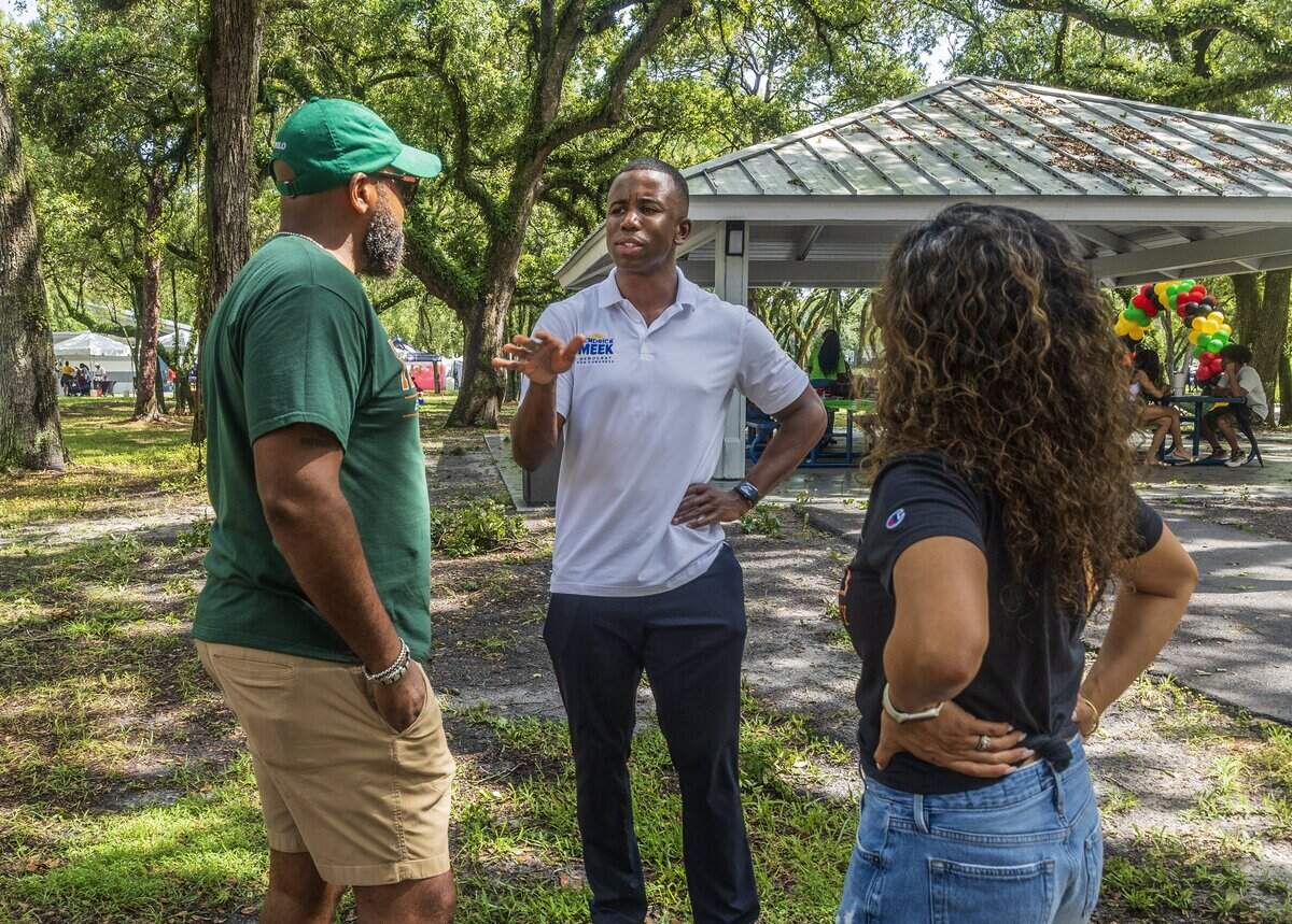 Kendrick Meek (center) talks with Florida Senator Senator Oscar Braynon II and his wife Melissa Braynon, as he rallies during the South Florida HBCU Picnic, to follow in his family's legacy and get elected to Congress, at the Rolling Oaks Park in Miami Gardens, on Saturday July 25, 2026.
