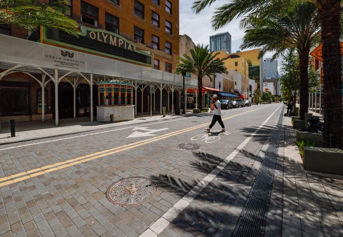 A pedestrian crosses a paved East Flagler street in front of the Olympia Theater after years of on-off construction in downtown Miami on Tuesday, August 4, 2026.