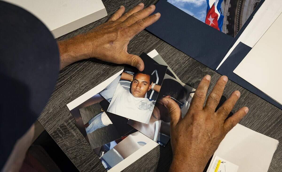 Raunel Sanchez looks at photos of his late son, Raudel Sanchez, at his home on Wednesday, July 29, 2026, in Hialeah, Fla. Raudel, 21, was murdered on Aug. 27, 2009. His death remains a cold case, and no one has been arrested in connection with the crime.