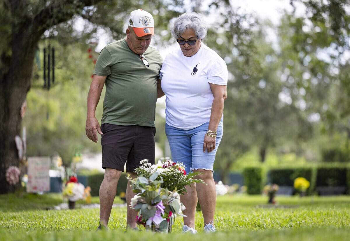 Raunel Sanchez and Vivian Texidor, the parents of the late Raudel Sanchez, pay their respects at their son’s gravesite at Caballero Rivero Woodlawn West on Sunday, Aug. 9, 2026, in Miami, Fla. Raudel, 21, was murdered on Aug. 27, 2009. His death remains a cold case, and no one has been arrested in connection with the crime.