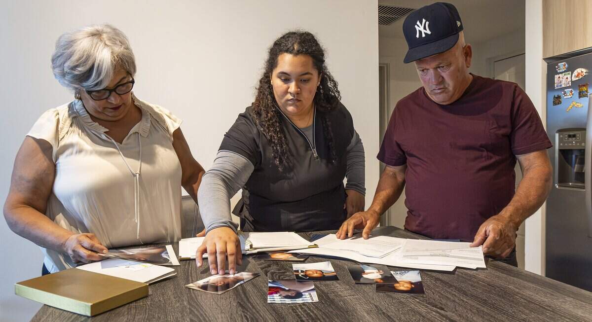 From left to right: Vivian Texidor, mother of the late Raudel Sanchez, Sabrina Sanchez, his sister, and Raunel Sanchez, his father, look at photos of Raudel at their home on Wednesday, July 29, 2026, in Hialeah, Fla. Raudel, 21, was murdered on Aug. 27, 2009. His death remains a cold case, and no one has been arrested in connection with the crime.